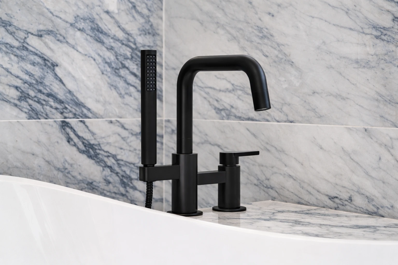 bathroom-remodeling-marlboro-nj-black-tub-filler-faucet.webp Matte black freestanding tub filler faucet installed against marble tile during a modern bathroom remodeling project in Marlboro, NJ.
