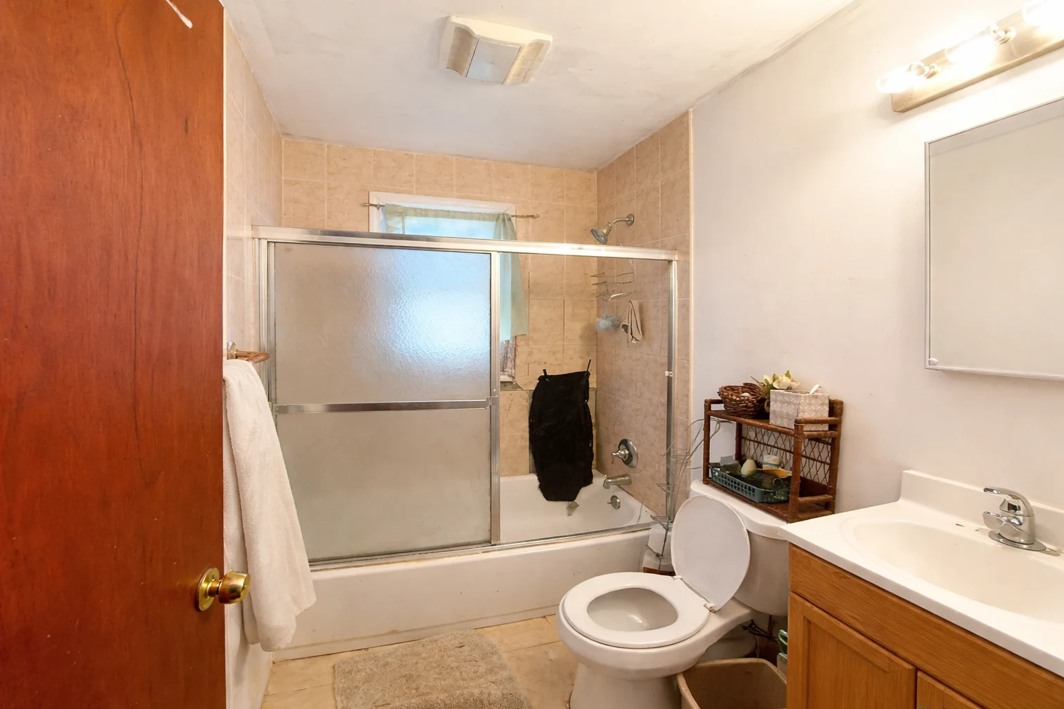 One day bathroomremodel transformation: old shower toa glass shower enclosure with built-in shelves and marble-style wall panels.