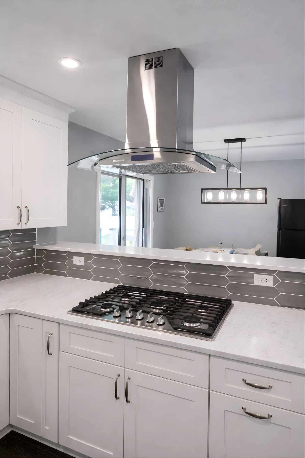 Stainless steel range hood installed above a cooktop as part of a modern kitchen remodeling project in Berkeley Township, NJ.