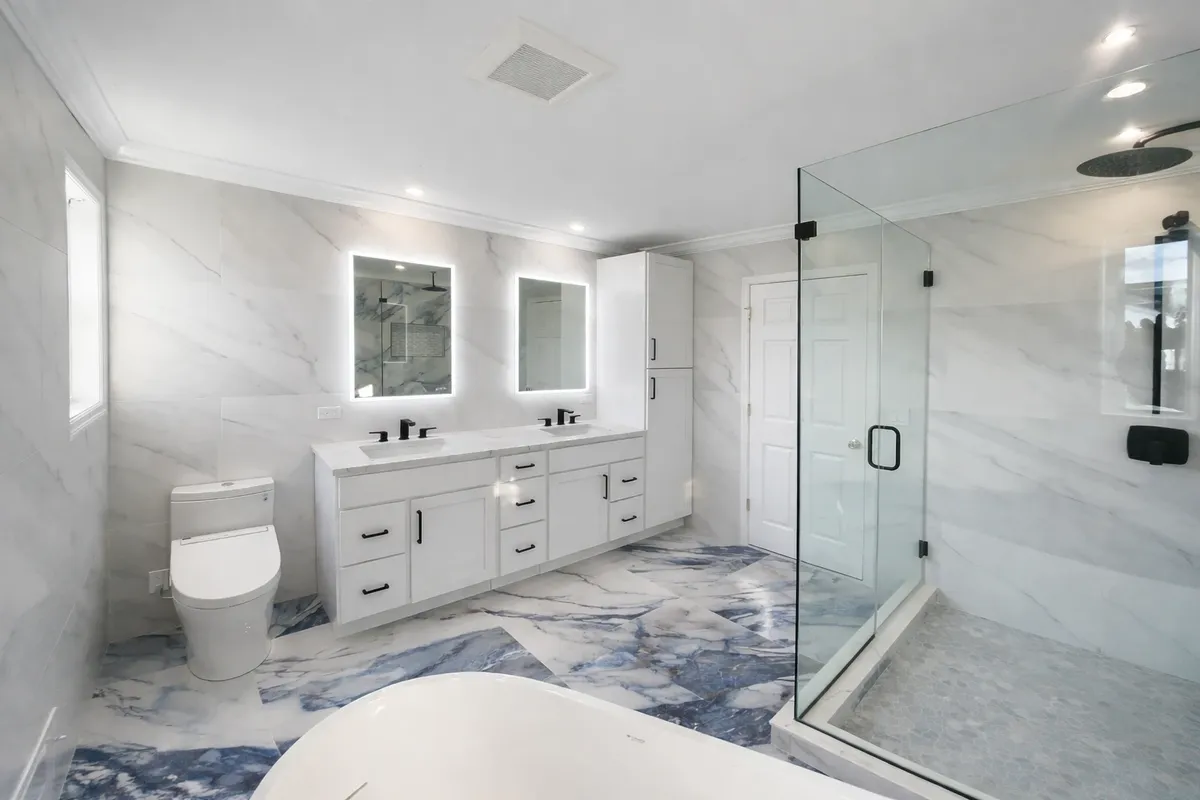 Modern small bathroom remodel with double vanity and glass shower by Gold Standard Bathrooms